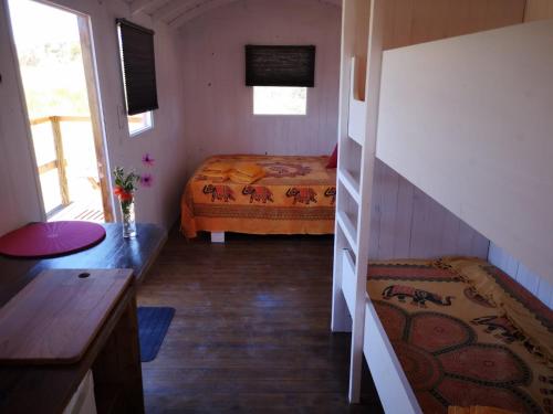 Habitación pequeña con cama y escalera en Moledos glamping en Aljezur