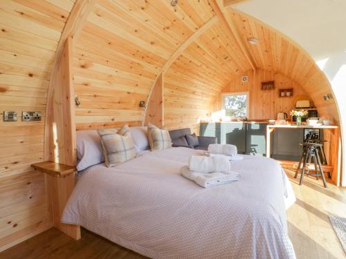 a large bed in a room with a wooden ceiling at Chapel Pod in Saltash