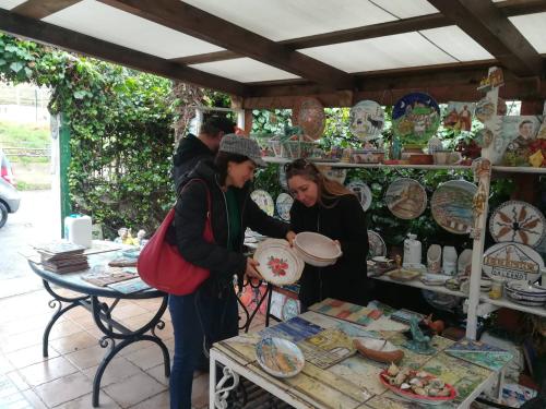 two women standing in front of a table with plates at Historical Center with Garden "The Beach and The Cliff" 4 in Agropoli