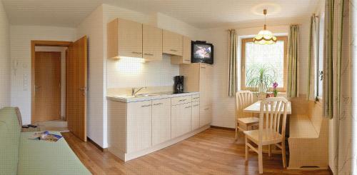 uma cozinha com uma mesa e uma sala de jantar em Appartements Schusterbauer em Naz-Sciaves