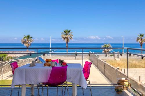 a table on a balcony with a view of the ocean at Terraces d'Orlando - Family Apartments with Sea View and Pool in Capo dʼOrlando