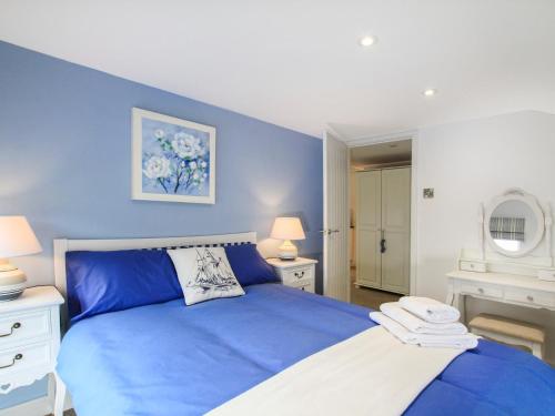 niebieska sypialnia z łóżkiem i 2 lampami w obiekcie Amolca w mieście Amlwch