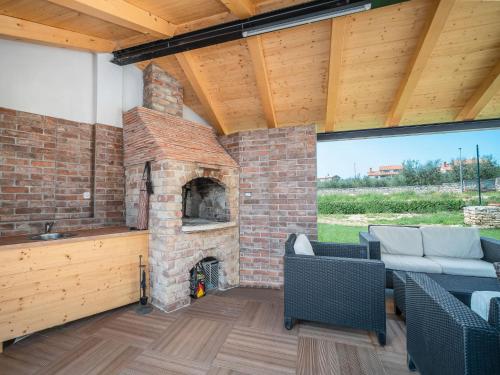 an outdoor living room with a brick fireplace at Apartment Ulika-4 by Interhome in Tar