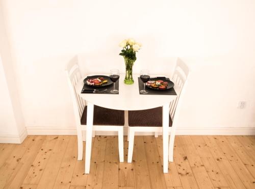 una mesa blanca con dos platos de comida. en White Lodge - central beach apartment, en Liepāja