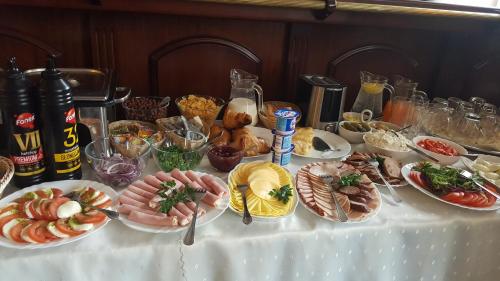 a table with many plates of food on it at Hotel Iskra in Rzeszów