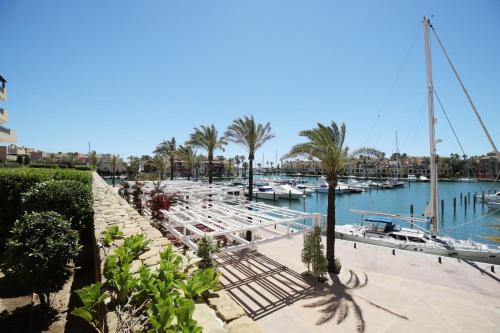 a marina with boats in the water and palm trees at Ribera del Marlin - Sotogrande in Sotogrande