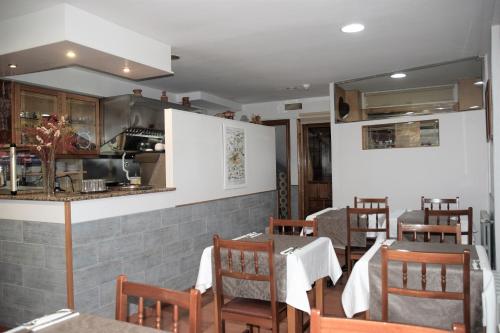 een eetkamer met tafels en stoelen en een keuken bij Hostal Anosa Casa in Santiago de Compostela