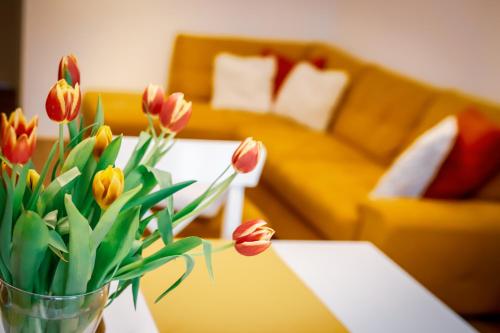 un jarrón de tulipanes sobre una mesa en una sala de estar en Cozy apartment in the downtown, en Győr