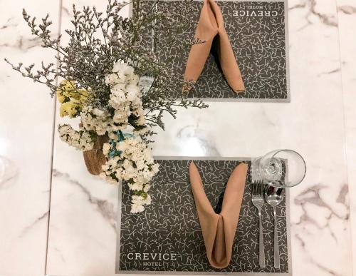 a table with a vase of flowers and shoes at CREVICE HOTEL in Davao City