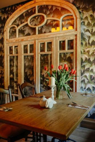 a wooden table with flowers on top of it at Zajazd Srebrna Gora in Kraków