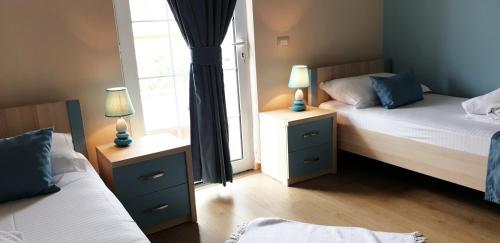 a bedroom with two beds and two lamps on night stands at Open Doors Bed & Breakfast in Shkodër