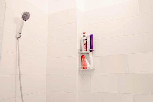 a bathroom with a shower with a toothbrush and tooth paste at White Lodge - central beach apartment in Liepāja