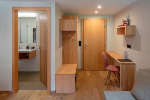 Apartamento pequeño con escritorio y lavabo en una habitación. en Hotel Nest- und Bietschhorn, en Blatten im Lötschental