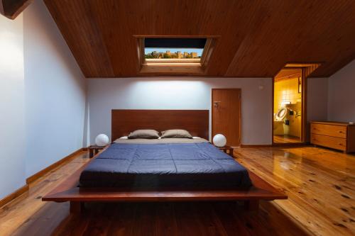 Schlafzimmer mit einem großen Bett mit einem Kopfteil aus Holz in der Unterkunft Home in Lisbon Duplex in Lissabon