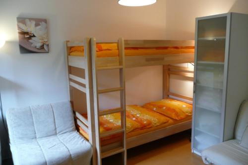 a bunk bed room with two bunk beds and a chair at Apartmán Dalibor II č. 305 in Špindlerův Mlýn