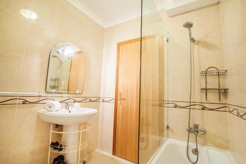 uma casa de banho com um lavatório e um chuveiro em Heart of Aveiro Apartment em Aveiro