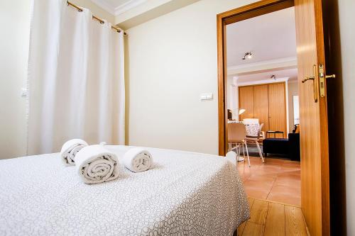 アヴェイロにあるHeart of Aveiro Apartmentのベッドルーム1室(白いベッド1台、タオル付)