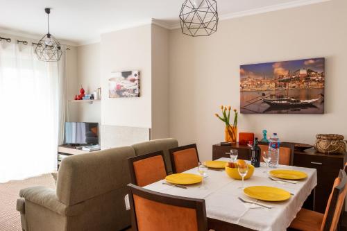 a dining room with a table and a couch at Madalena Beach Apartment by MP in Madalena