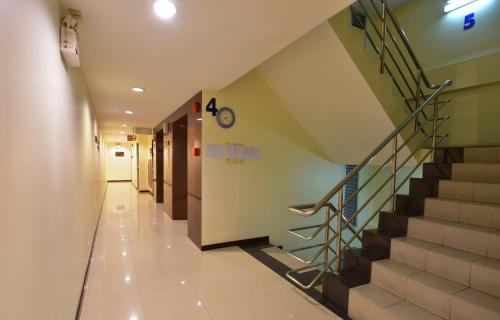 a hallway of a hospital with stairs and a stair case at Grand Business Inn in Bangkok