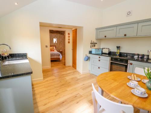 a kitchen and dining room with a wooden table at The Tractor Shed in Oswestry