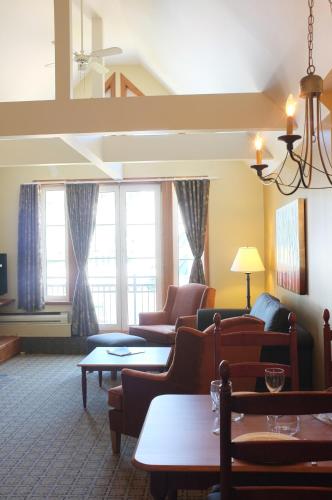 a living room with couches and tables and windows at Place Saint Bernard Mont Tremblant in Mont-Tremblant
