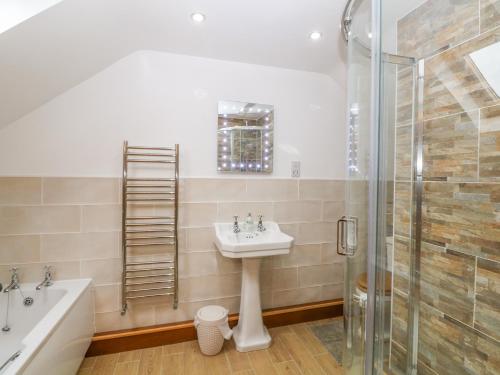 a bathroom with a sink and a shower at Beudy Tyddyn in Llandyfrydog