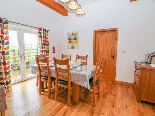 a dining room with a table and chairs at Beudy Tyddyn in Llandyfrydog