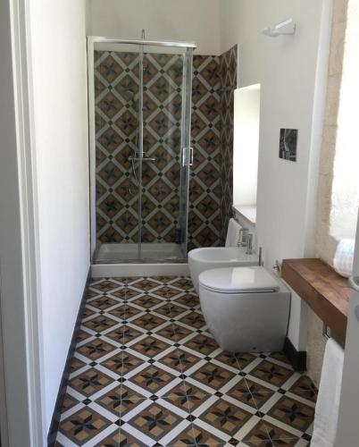 a bathroom with a shower and a toilet and a sink at Isabella di Castiglia Apartments in Siracusa