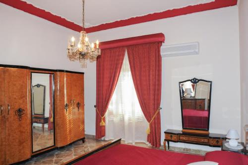 1 dormitorio con cama, espejo y lámpara de araña en CASA CALISI, en Terrasini
