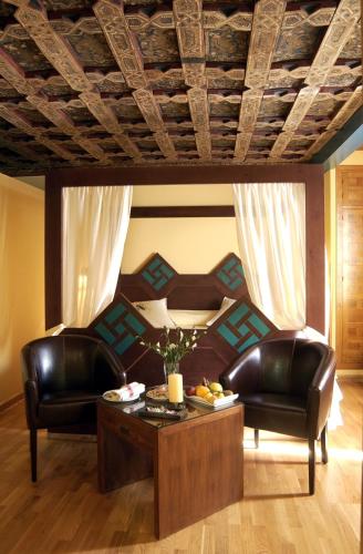 a living room with two leather chairs and a coffee table at Hotel Spa La Casa Mudéjar in Segovia