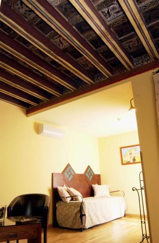 a bedroom with a bed and a chair at Hotel Spa La Casa Mudéjar in Segovia