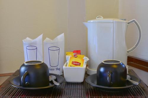 two tea pots and a blender on a table at Grand Business Inn in Bangkok