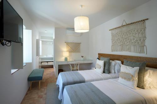 a hotel room with two beds and a television at Alte Tradition Guest House in Alte