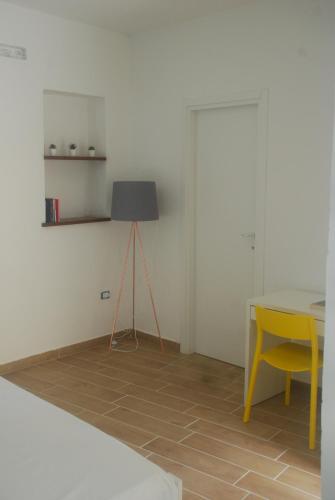 a room with a table and a lamp and a yellow chair at La Torretta di Alessia in Ogliastro Cilento
