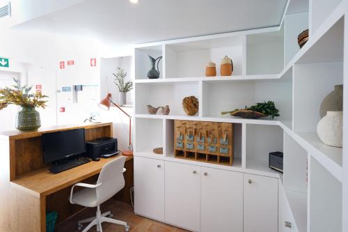 a white office with a desk and a computer at Alte Tradition Guest House in Alte