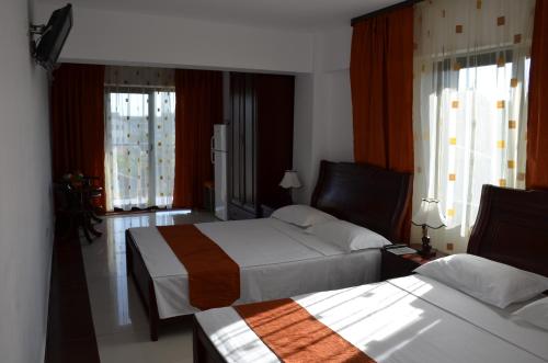 a hotel room with two beds and two windows at SmartHouse in Costinesti