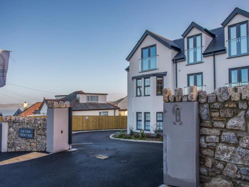 a house with a stone wall and a driveway at Beach Lookout in Benllech