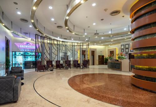 a lobby of a hotel with chairs and tables at Radisson Gurugram Sohna Road City Center in Gurgaon