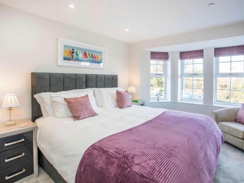 a bedroom with a large bed and a couch and windows at Beach Lookout in Benllech