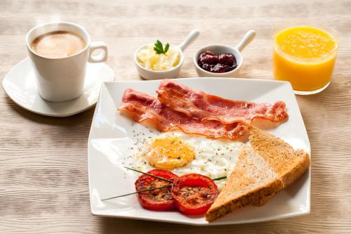 a plate with eggs bacon and toast and a cup of coffee at 3 Studio in Tbilisi City