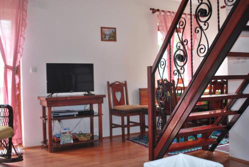 ein Wohnzimmer mit einer Treppe und einem TV in der Unterkunft Vile M&S in Kopaonik