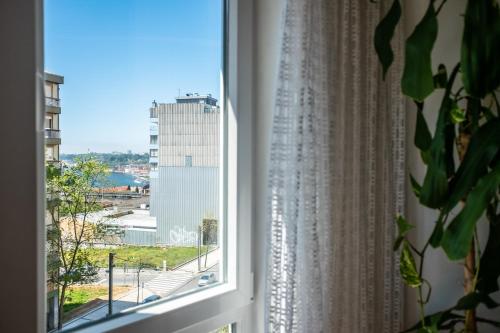 a window with a view of a city at Avenida: Central, Garage, Metro in Vila Nova de Gaia