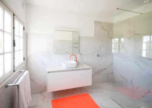 a white bathroom with a sink and a mirror at B&B Villa Branca Barreiros AL98139 in Barreiros