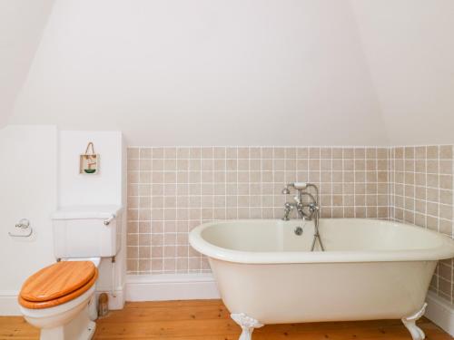 a bathroom with a white tub and a toilet at Badgers Loft in Penzance
