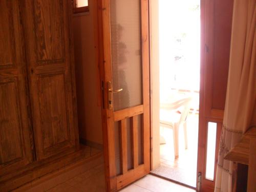 an open wooden door in a room with a window at Hotel Plammas in Santa Maria Navarrese