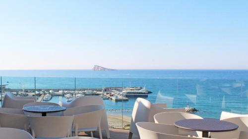 a view of the ocean from a restaurant with tables and chairs at Hotel Montemar in Benidorm