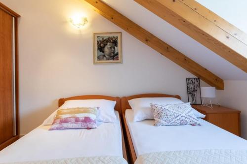 two beds sitting next to each other in a room at Emily Apartment in Suđurađ