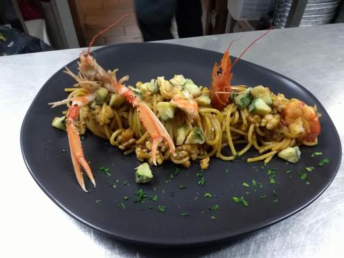a plate of pasta with shrimp and vegetables on a table at Casolare Casa Ricci in Riotorto