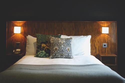 a bedroom with a bed with pillows and two lamps at The Mill at Conder Green in Conder Green