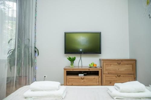 ein Schlafzimmer mit einem TV an einer weißen Wand in der Unterkunft Red Kurka Apartments in Krakau